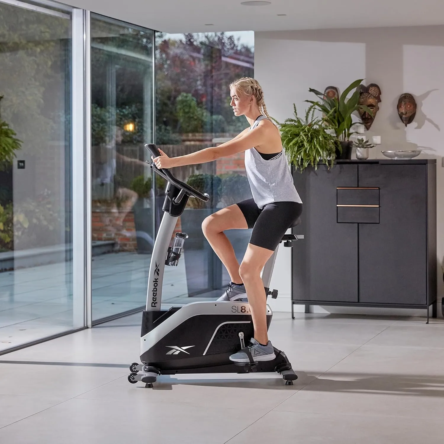 Reebok Fitness Stationary Bike: Bluetooth Compatible Indoor Cycling Bike, 24 Resistance Levels, 12 Workouts, Upright Exercise Bike with Gel Pad Saddle